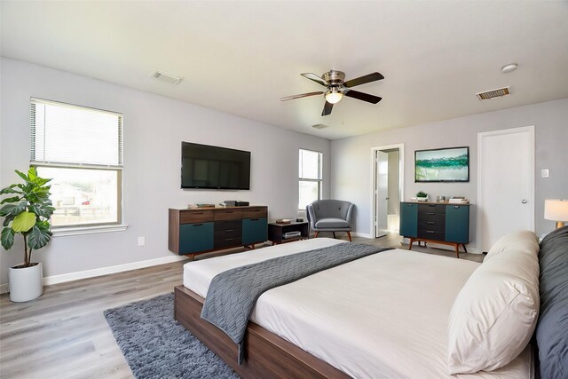 bedroom with visible vents, baseboards, and wood finished floors