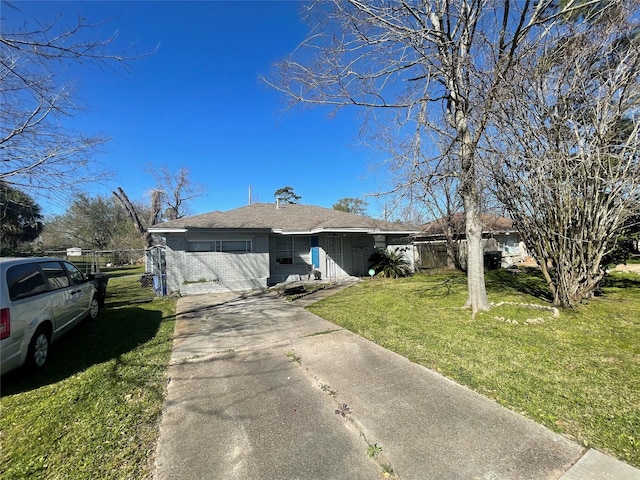 single story home featuring a gate, brick siding, a front lawn, and fence