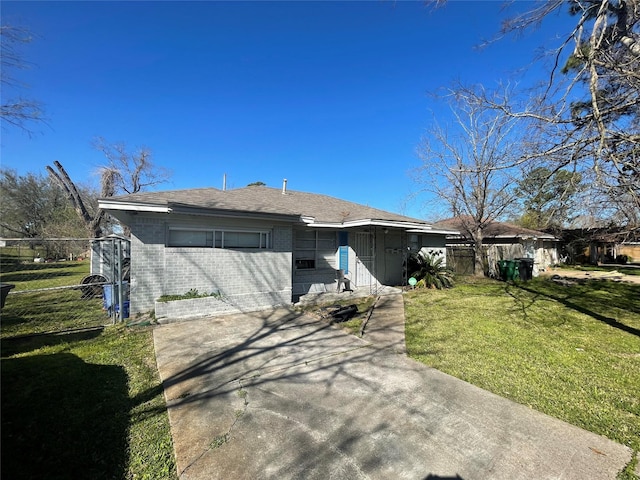 view of front of property with a front lawn, fence, and brick siding