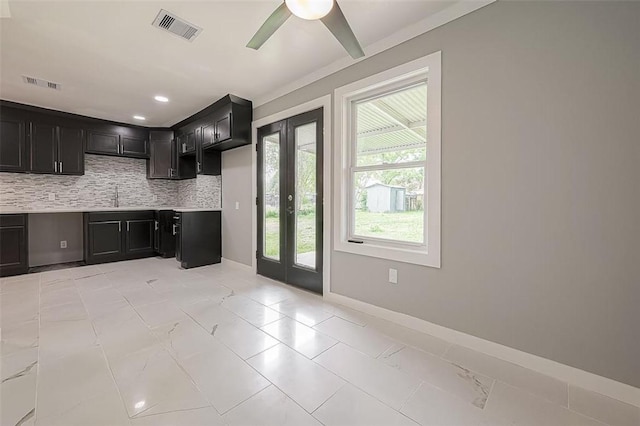 kitchen with dark cabinetry, visible vents, and backsplash