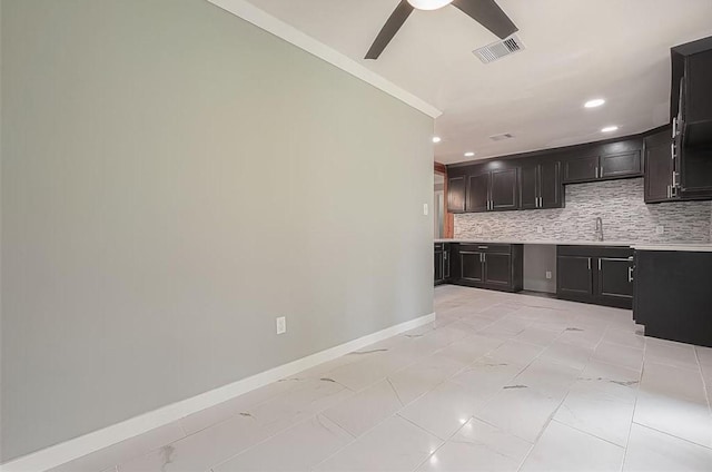 kitchen with baseboards, visible vents, ceiling fan, decorative backsplash, and light countertops