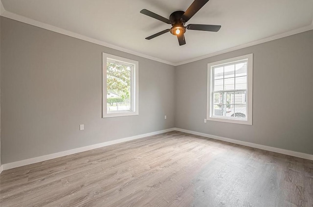 empty room featuring baseboards, wood finished floors, and crown molding