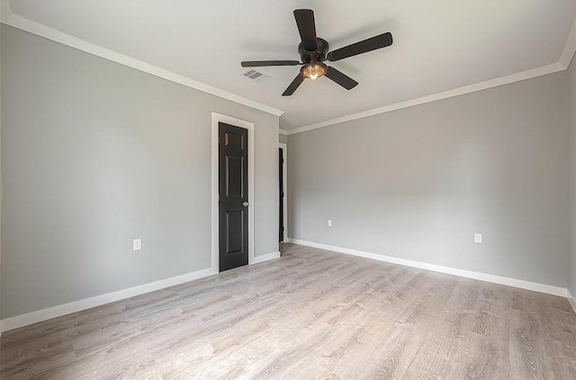 spare room featuring ornamental molding, wood finished floors, visible vents, and baseboards