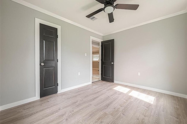 unfurnished bedroom featuring visible vents, light wood-style floors, baseboards, and ornamental molding