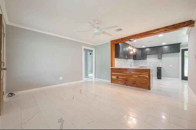 kitchen featuring baseboards, light countertops, crown molding, tasteful backsplash, and open floor plan