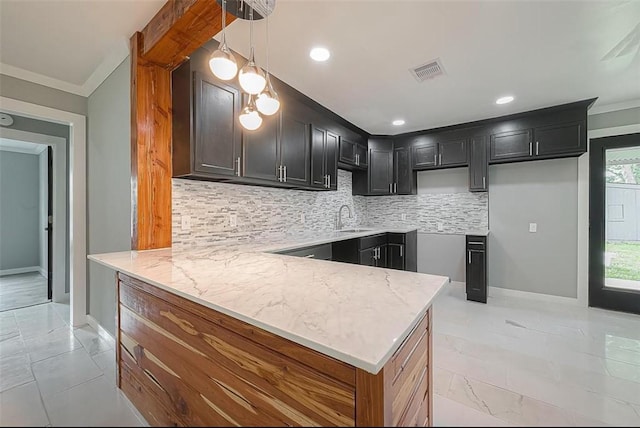 kitchen with light stone counters, visible vents, a peninsula, and tasteful backsplash