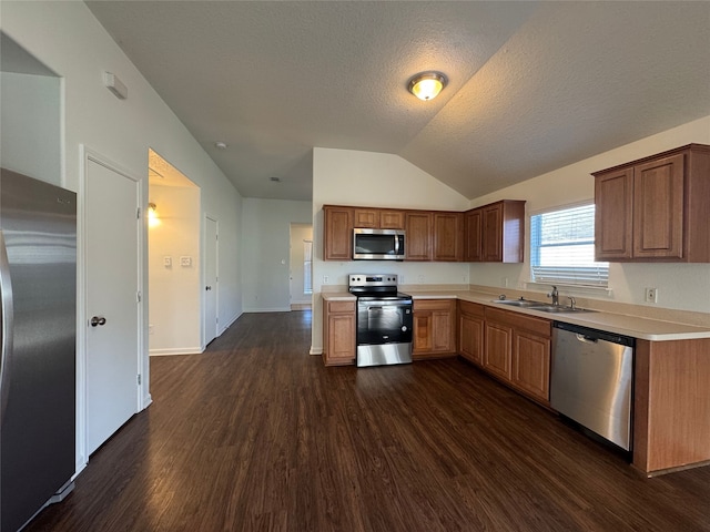 kitchen featuring dark wood-type flooring, a sink, stainless steel appliances, light countertops, and lofted ceiling