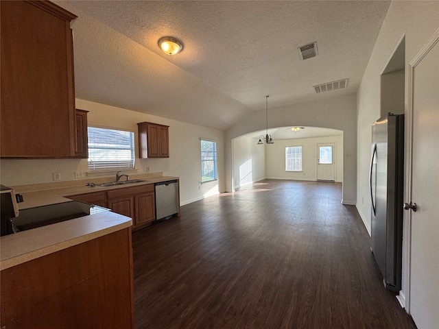 kitchen with a sink, lofted ceiling, visible vents, and stainless steel appliances