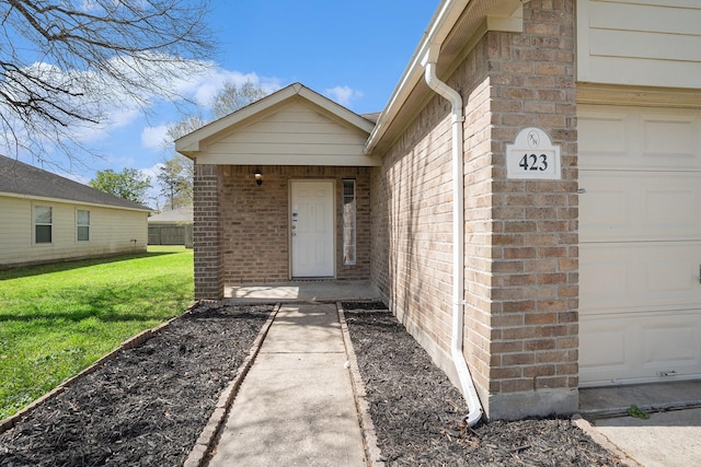 entrance to property with a lawn and brick siding