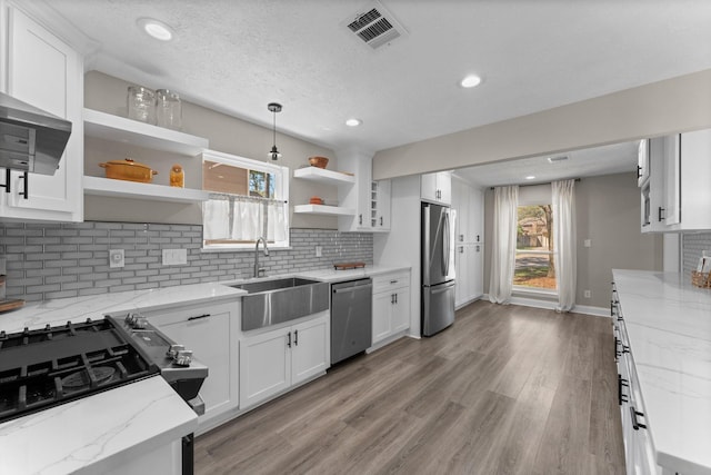 kitchen featuring visible vents, open shelves, white cabinets, stainless steel appliances, and a sink