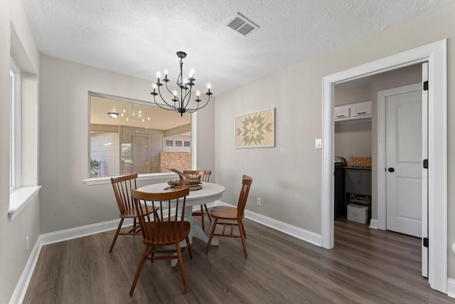 dining room featuring a textured ceiling, wood finished floors, visible vents, and a chandelier