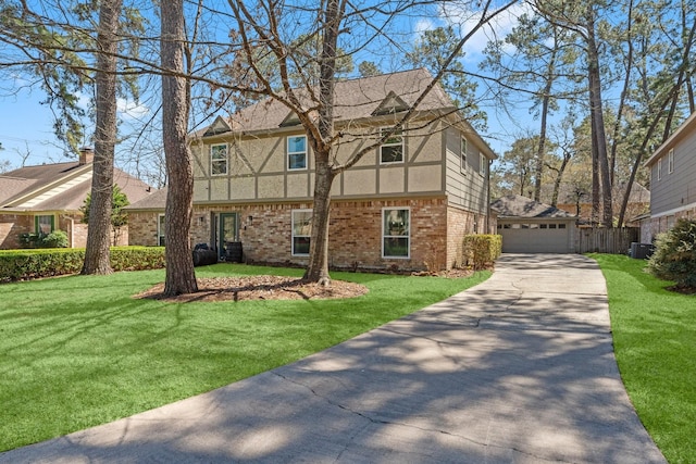 view of side of property with stucco siding, a lawn, a detached garage, central AC, and brick siding