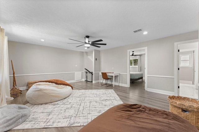 living area featuring a ceiling fan, wood finished floors, visible vents, baseboards, and recessed lighting