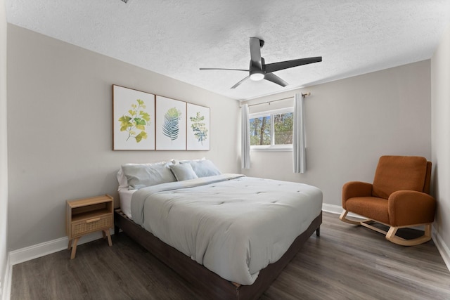 bedroom with dark wood finished floors, a textured ceiling, and baseboards