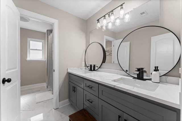 bathroom featuring visible vents, baseboards, double vanity, a sink, and marble finish floor