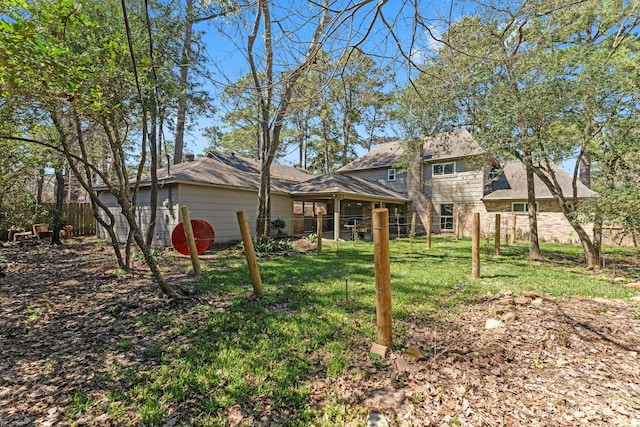 rear view of house with a lawn and fence