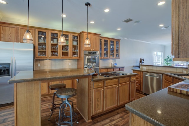 359 Cambridge Dr, New Braunfels, TX 78132 - kitchen with stainless steel appliances, visible vents, brown cabinetry, and dark wood-style flooring