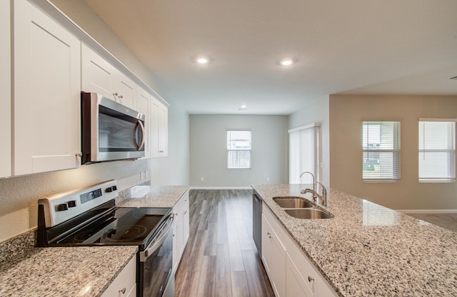 kitchen with dark wood finished floors, white cabinets, appliances with stainless steel finishes, and a sink