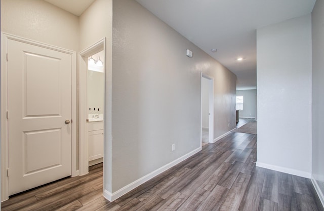 corridor with dark wood finished floors and baseboards