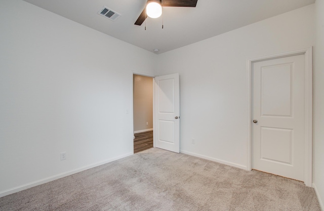 unfurnished room featuring visible vents, ceiling fan, baseboards, and carpet