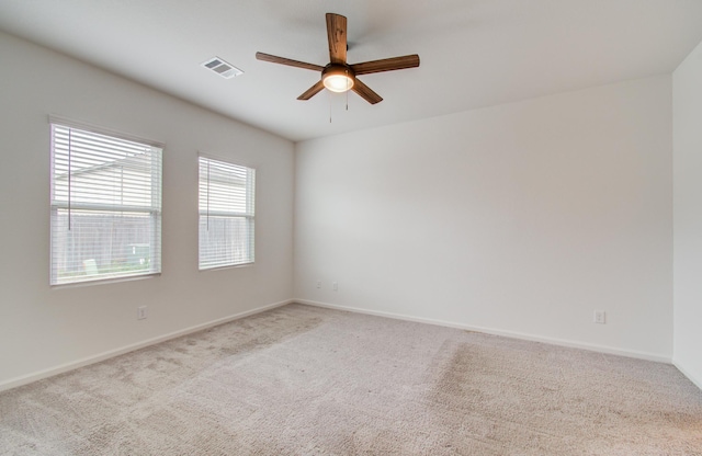 empty room featuring visible vents, baseboards, carpet, and ceiling fan