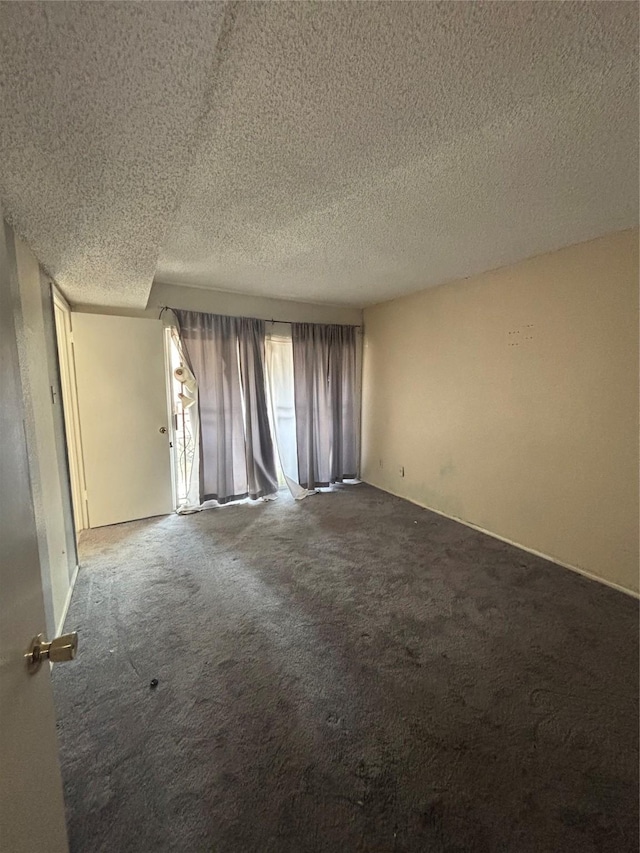 unfurnished room featuring carpet and a textured ceiling