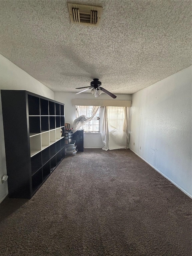 unfurnished living room featuring visible vents, carpet floors, a textured ceiling, and a ceiling fan