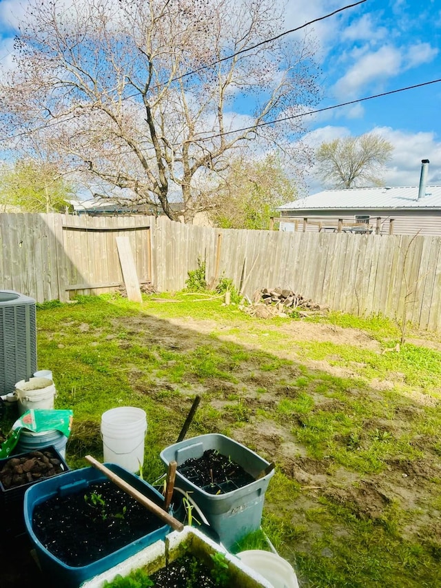 view of yard with central AC unit and a fenced backyard