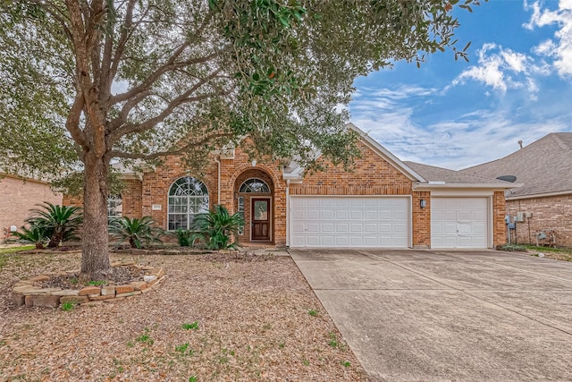 view of front of home featuring driveway, brick siding, and an attached garage