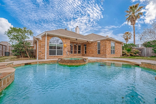 view of pool featuring fence and a pool with connected hot tub