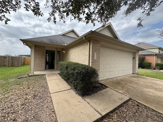 ranch-style home featuring brick siding, an attached garage, driveway, and fence