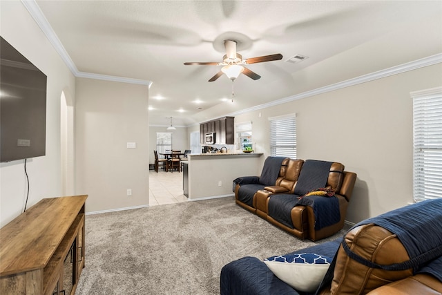 living room with visible vents, plenty of natural light, light colored carpet, and crown molding