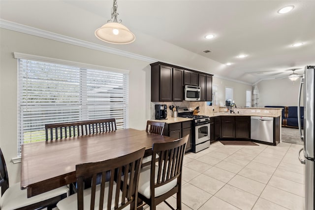 kitchen featuring appliances with stainless steel finishes, crown molding, and a sink