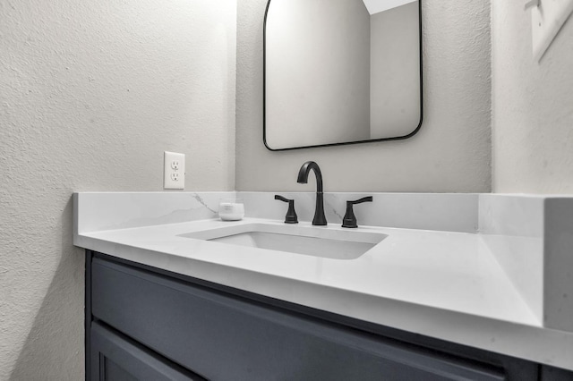 bathroom with vanity and a textured wall