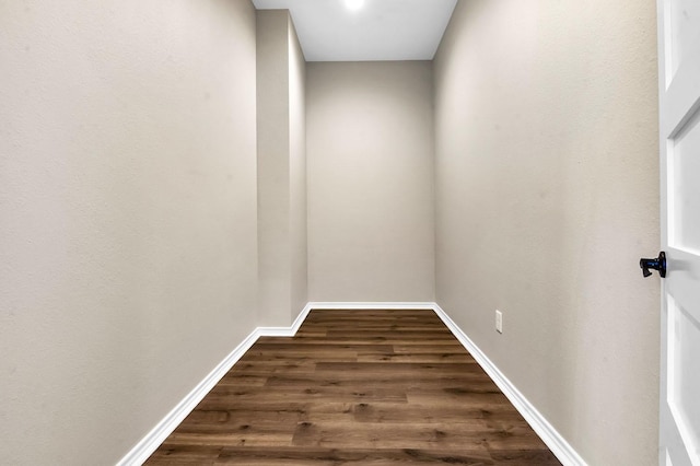 hall featuring baseboards and dark wood-style flooring