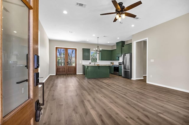 kitchen with green cabinetry, visible vents, appliances with stainless steel finishes, and dark wood-style flooring