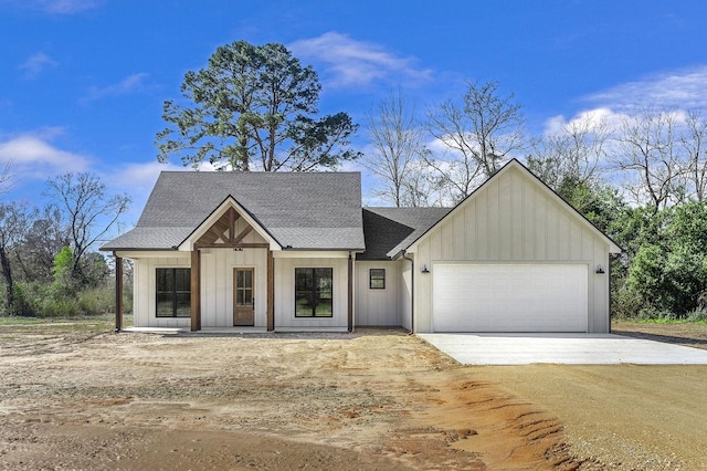 modern farmhouse featuring concrete driveway, an attached garage, board and batten siding, and a shingled roof