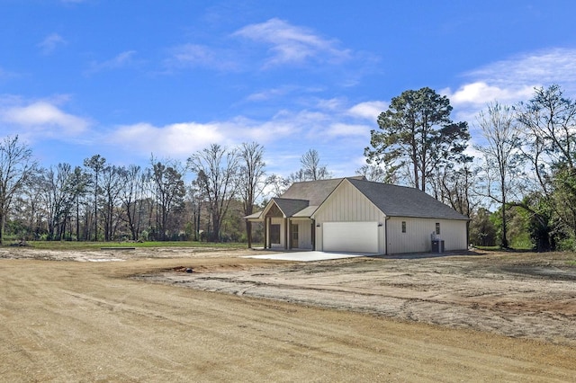 view of front of house with an attached garage and dirt driveway