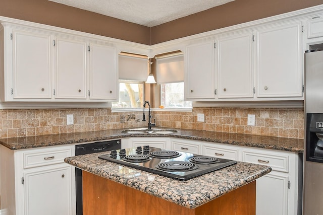 kitchen with a sink, electric stovetop, a center island, white cabinets, and decorative backsplash