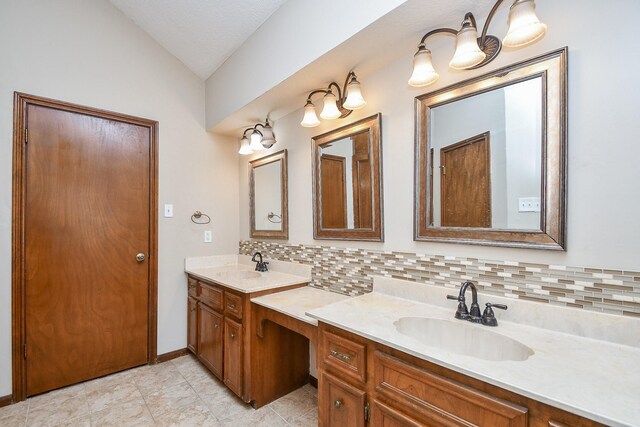 bathroom with a sink, backsplash, and vaulted ceiling