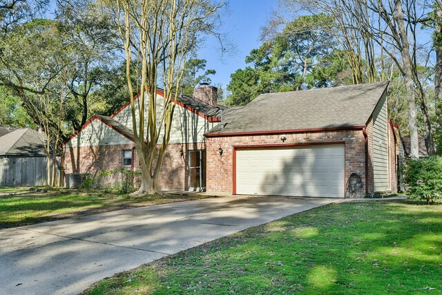 ranch-style home with a front yard, driveway, an attached garage, a chimney, and brick siding