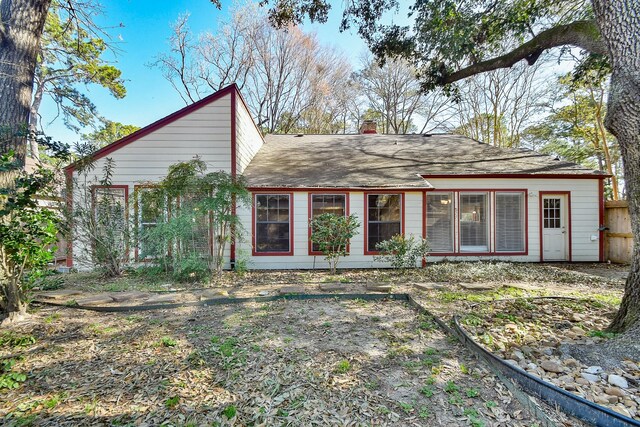 back of house featuring a chimney and fence