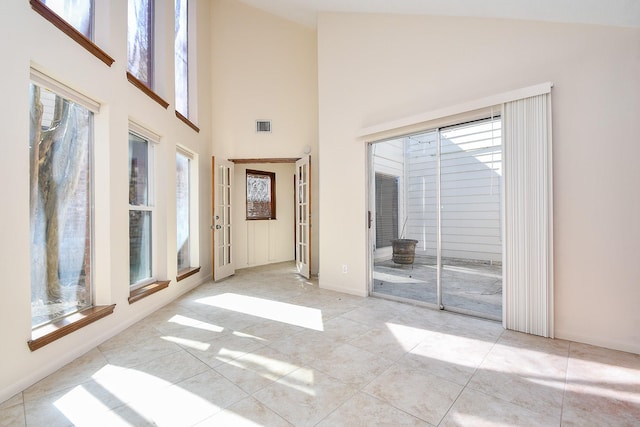 tiled spare room with vaulted ceiling and visible vents