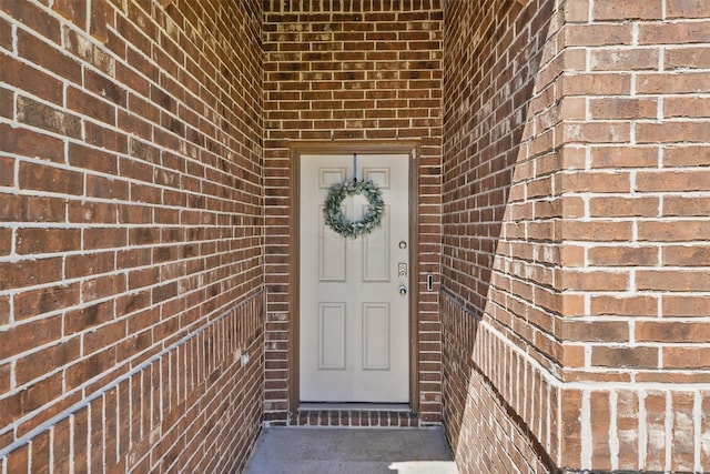 view of exterior entry with brick siding