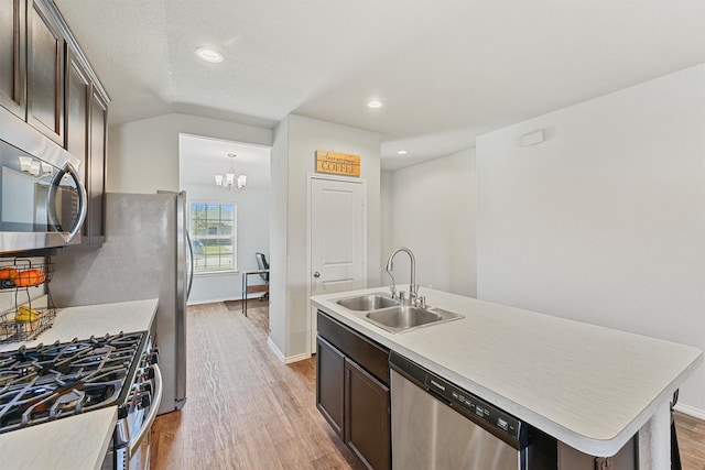 kitchen with a sink, light wood-type flooring, dark brown cabinetry, and appliances with stainless steel finishes