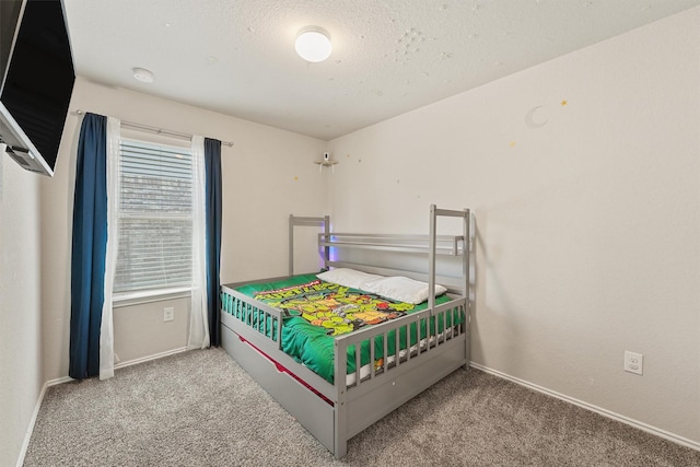 carpeted bedroom featuring baseboards and a textured ceiling