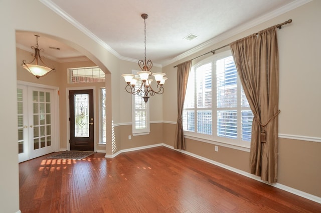 entryway with wood finished floors, visible vents, baseboards, arched walkways, and ornamental molding