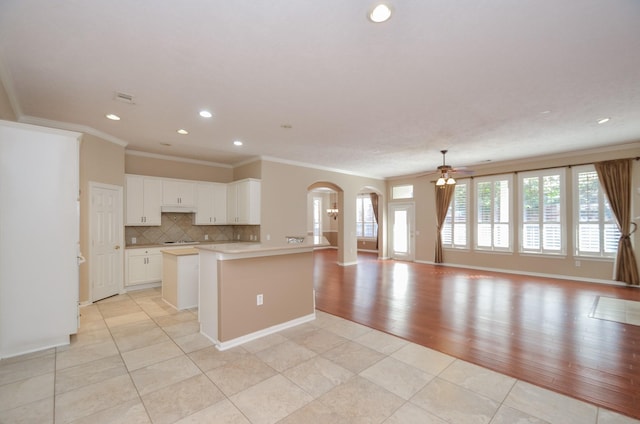 kitchen featuring light countertops, open floor plan, plenty of natural light, and tasteful backsplash