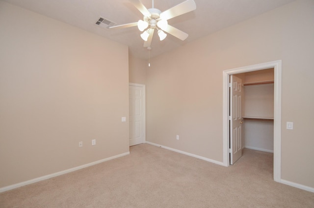 unfurnished bedroom featuring visible vents, light carpet, a closet, baseboards, and a spacious closet