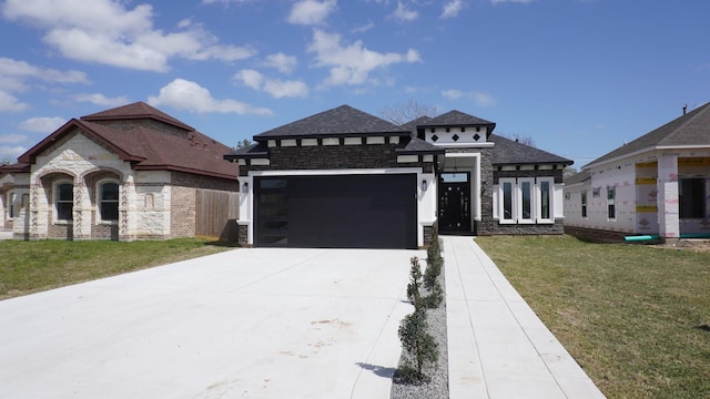 view of front facade featuring a front lawn, an attached garage, stone siding, and driveway